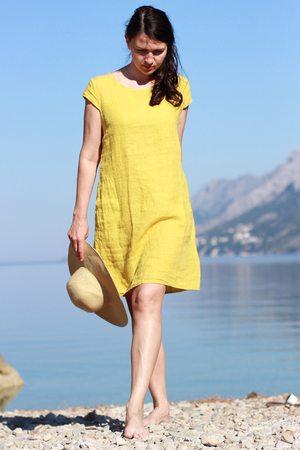 Jednobarevné dámské letní šaty ze 100% lnu v délce nad kolena s kapsami na předním díle. Volný střih, jako