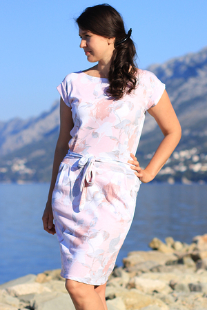 Letní dámské bavlněné šaty s barevným květinovým vzorem. Šaty mají lodičkový výstřih a krátký rukáv s
